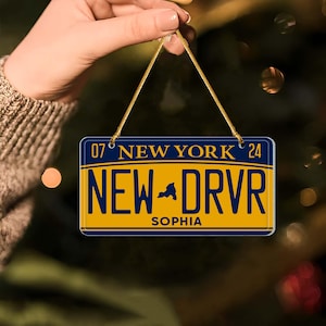 Puede incluir: Un adorno de placa de matr&iacute;cula de Nueva York azul y amarillo con el texto "NEW DRVR" y el nombre "SOPHIA" impreso en &eacute;l.
