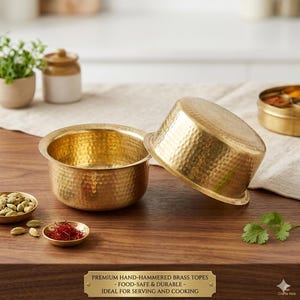 Puede incluir: Dos cuencos de latón martillados a mano con una superficie texturizada, exhibidos sobre una mesa de madera. Los cuencos son de color dorado y tienen un diseño martillado. El texto en la placa de latón dice: PREMIUM HAND-HAMMERED BRASS TOPES - FOOD-SAFE & DURABLE - IDEAL FOR SERVING AND COOKING.