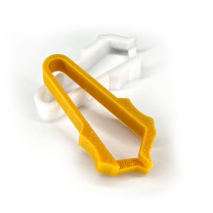 Peut inclure: Un outil en plastique jaune avec une surface texturée. L'outil est conçu pour saisir et maintenir des objets.