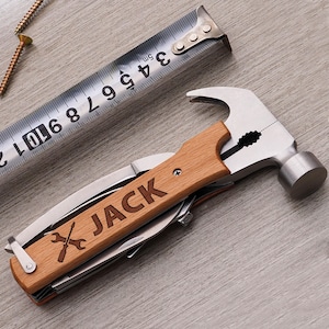 May include: A multi-tool with a hammer head and a wooden handle. The handle is engraved with the name "JACK" and a pair of crossed wrenches.