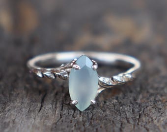 Peut inclure: Une bague en argent avec une bande torsadée délicate et une pierre précieuse de forme marquise bleu clair.