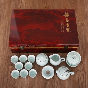 May include: A tea set with a red wooden box. The set includes a teapot, cups, a pitcher, and a serving bowl. The tea set is light blue and white, with a dark red wooden box. The box has gold text.