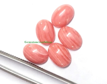 Pode incluir: Cinco cabochões ovais de pedra preciosa rosa e branca. Os cabochões têm um padrão estriado e são lisos e polidos.