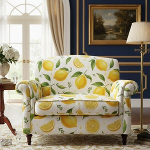 Puede incluir: Un sillón blanco con un estampado de limones. La silla presenta un diseño repetido de limones amarillos y hojas verdes sobre un fondo blanco. La silla tiene brazos enrollados y patas de madera oscura.
