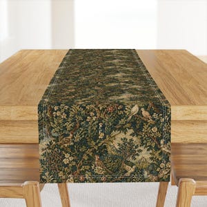 May include: A rectangular table runner featuring a dark green tapestry-style pattern with intricate illustrations of various birds perched among dense foliage, blooming flowers, and trees, finished with a clean white stitched border.