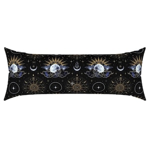 May include: A long, black body pillow with a celestial pattern. The design features gold suns, moons, stars, and compass-like symbols. The pillow is rectangular and has a soft, inviting appearance.