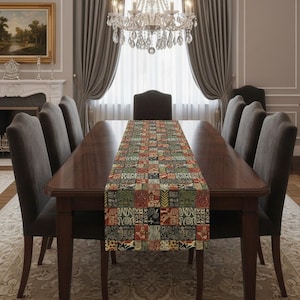 May include: A dining table with a patterned table runner and six chairs. The runner has a patchwork design in red, green, and black. A chandelier hangs above the table. The table is approximately 180 cm long.
