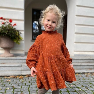 Rust cotton girl dress, with puffed sleeves, ruffle neck and long sleeves.