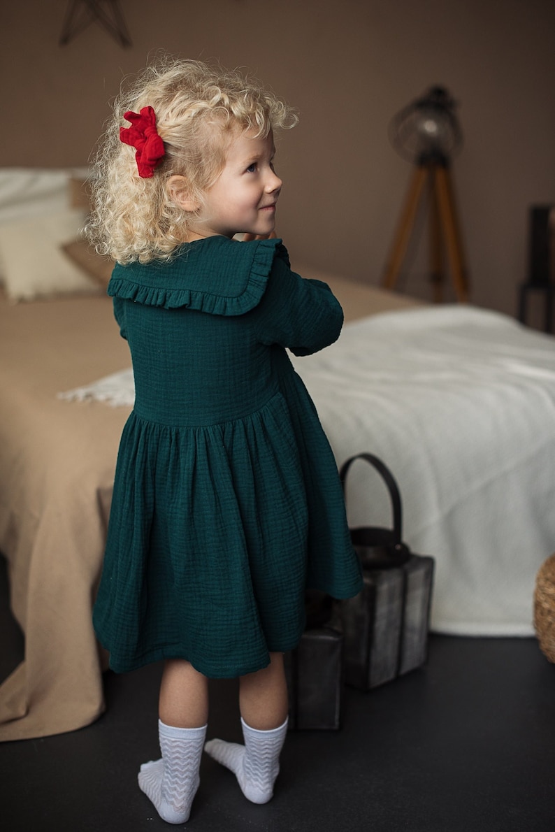 Girl wearing collared cotton dress, with long sleeves, dark green color