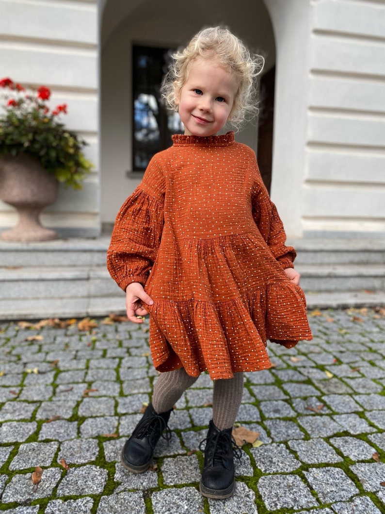 Rust cotton girl dress, with puffed sleeves, ruffle neck and long sleeves.