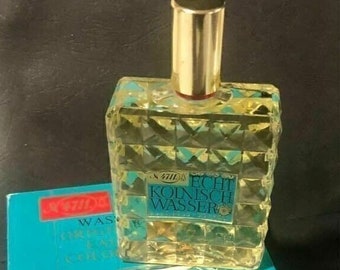 May include: A blue and gold box with a clear glass bottle of cologne inside. The bottle has a gold cap and a label that reads "4711 Echt Kolnisch Wasser".