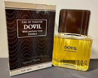 May include: A brown and gold bottle of Dovil Eau de Toilette with a black and white box. The box has a black and white pattern and the text "Dovil Eau de Toilette, With perfume from France, Natural Spray, 100 ml, For Men".
