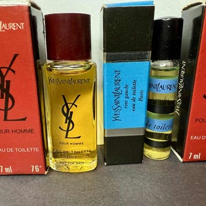 May include: Several Yves Saint Laurent miniature perfume bottles are displayed. The bottles are in red, black, and blue boxes. The bottles are labeled "Pour Homme" and "Eau de Toilette". The bottles are 7 ml.