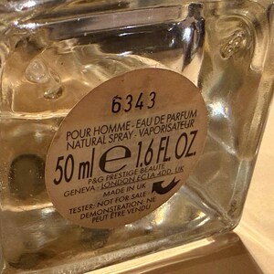 Puede incluir: Un frasco de perfume de vidrio transparente con una etiqueta beige. La etiqueta dice "POUR HOMME - EAU DE PARFUM NATURAL SPRAY - VAPORISATEUR" y "50 ml e 1.6 FL. OZ.". La botella est&aacute; marcada "TESTER: NOT FOR SALE".