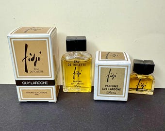 May include: Four vintage bottles of Guy Laroche's Fidji Eau de Toilette perfume. The bottles are in various sizes, with the perfume liquid appearing yellow. The packaging includes boxes with the Fidji logo and text.