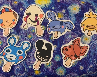 May include: A set of ten colorful cartoon character popsicle stickers. The characters include a yellow duck, a red fox, a blue bunny, a black bunny, a white ghost, and a red and blue clown. The stickers are all on a white background.
