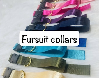 May include: A collection of nylon collars in various colors including pink, purple, navy blue, teal, olive green, and beige. Each collar features a black plastic side-release buckle and a gold-toned metal D-ring. The text Fursuit collars is visible.