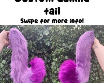 May include: Two custom canine tails, one in each hand, against a backdrop of green foliage. The tails are a gradient of purple and magenta, with the text "Custom canine tail" and "Swipe for more info!" in black.