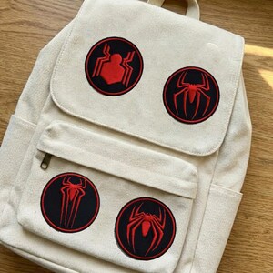 Może przedstawiać: Zestaw trzech ceramicznych kubk&oacute;w z nakrapianym, matowym wykończeniem. Kubki są w odcieniach kremu, jasnoszarym i ciemnoszarym. Każdy kubek ma prosty, minimalistyczny design, idealny do kawy lub herbaty.