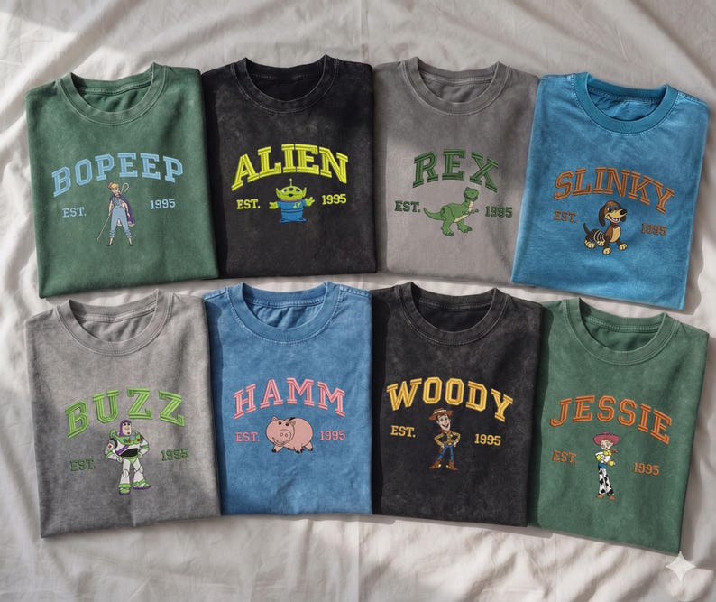 May include: Eight crew neck t-shirts in various colors, each featuring a character from the Toy Story franchise, including Bo Peep, Alien, Rex, Slinky, Buzz, Hamm, Woody, and Jessie, with their names, the text EST. 1995, and a graphic illustration.