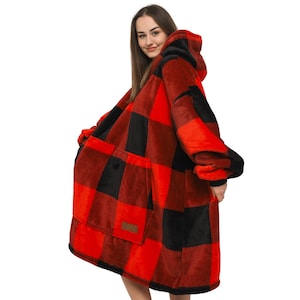Pode incluir: Casaco de cobertor de capuz oversized em xadrez vermelho e preto com um grande bolso frontal.