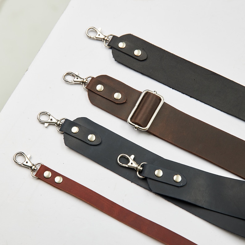 Puede incluir: Cuatro correas de c&aacute;mara de cuero con cierres plateados y hebillas ajustables. Las correas son de diferentes colores: negro, marr&oacute;n, marr&oacute;n oscuro y rojo.
