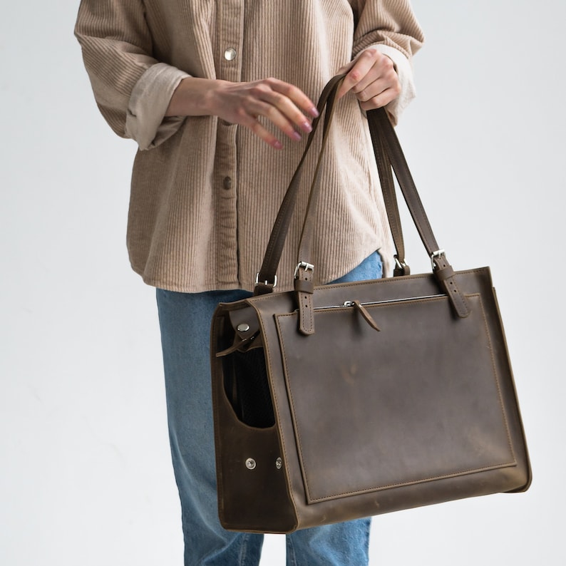 Pu&ograve; includere: Una borsa tote in pelle marrone con una tasca con cerniera e due manici regolabili. La borsa ha un aspetto invecchiato ed &egrave; realizzata in pelle di alta qualit&agrave;.