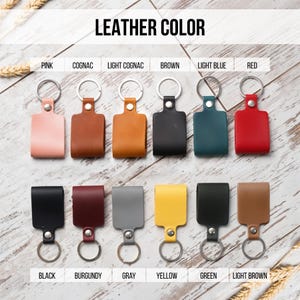 May include: Keychains in various colors, including pink, cognac, light cognac, brown, light blue, red, black, burgundy, gray, yellow, green, and light brown. The keychains are made of leather and have a metal ring.