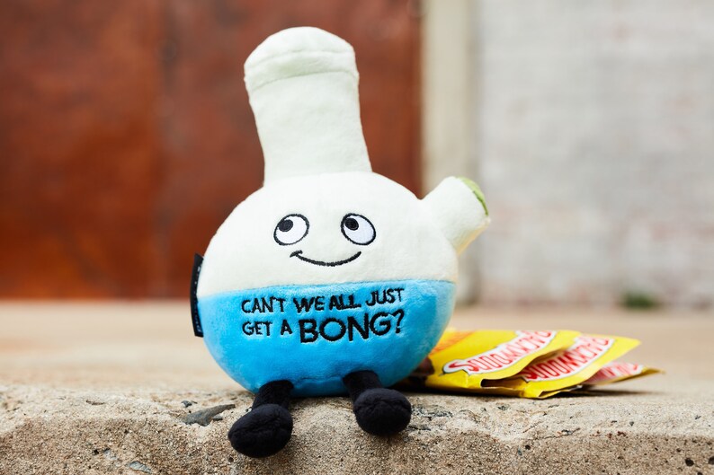K&ouml;nnte beinhalten: Ein blaues und wei&szlig;es Pl&uuml;schspielzeug in Form einer Bong mit einem l&auml;chelnden Gesicht und dem Text "Can't we all just get a bong?"