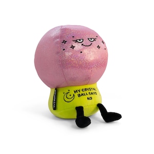 May include: A plush toy crystal ball with a pink, glittery top and a yellow base. The crystal ball has an embroidered face with a smug expression and star accents. The base reads "MY CRYSTAL BALL SAYS NO."