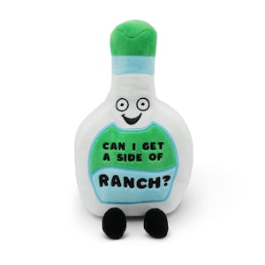 May include: A plush, white ranch dressing bottle with a green top and a light blue band. The bottle has a smiling face and the text "CAN I GET A SIDE OF RANCH?" in green and blue.