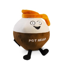 May include: A brown and white plush toy shaped like a coffee pot with a smiling face and the text "POT HEAD" on the front. The toy has orange fabric around the top and black legs.