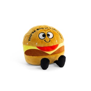 May include: A plush toy shaped like a hamburger with a smiling face and the text "You're bun in a million".