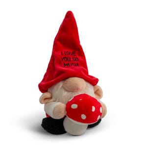 May include: A red plush gnome with a white beard and a red hat that says "I love you so mush". The gnome is holding a red and white mushroom.