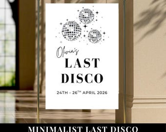 May include: A white rectangular welcome sign suspended on a gold metal frame. The sign features three black and white disco ball illustrations with star accents. Text reads: Olivia's LAST DISCO 24TH - 26TH APRIL 2026 in black serif and script fonts.