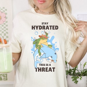 Stay Hydrated Frog - Unisex T-Shirt, Cowboy Frog Riding Dolphin, Drink Water Funny Graphic Tee