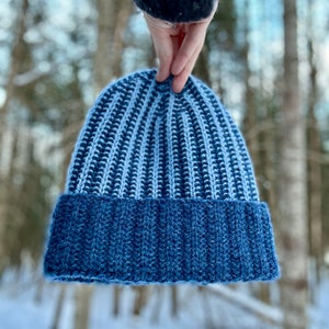 May include: A blue and white striped knit beanie with a blue fold-over brim.