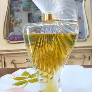 Puede incluir: Una taza de cer&aacute;mica blanca con un asa negra y el texto "But First, Coffee" en negrita negra. La taza est&aacute; llena de un l&iacute;quido oscuro, probablemente caf&eacute;, y se encuentra sobre una superficie de color claro.