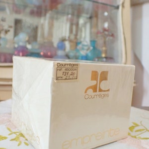 May include: A white box with gold lettering for a Courr&egrave;ges Empreinte perfume. The box has a price tag with the text "ref: 450004, 131,20, prix: 21,00".