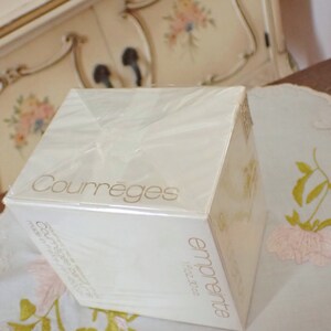 May include: A white box with a gold label that reads "Courr&egrave;ges" and "empreinte fragrance". The box is wrapped in clear plastic.