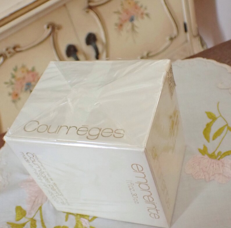 May include: A white box with a gold label that reads "Courr&egrave;ges" and "empreinte fragrance". The box is wrapped in clear plastic.
