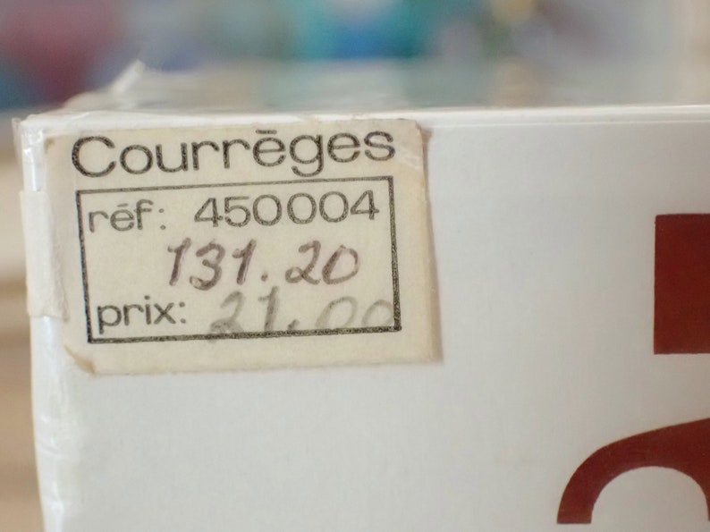 May include: A white box with a price tag that reads "Courr&egrave;ges" with a reference number of "450004" and a price of "131.20" and "21.00".