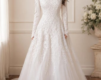 Abito da sposa sobrio in pizzo floreale, modello a trapezio con collo alto e maniche lunghe.