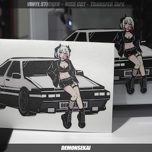 May include: A white car with a black anime girl character sitting on the roof. The car has a black bumper and black wheels. The girl has black hair, a black jacket, and a black skirt. She is holding a pink lollipop in her mouth. The text "DEMONSEKAJ" is at the bottom of the image.