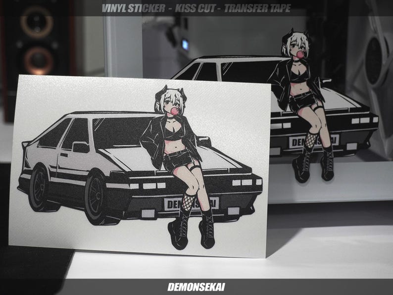 May include: A white car with a black anime girl character sitting on the roof. The car has a black bumper and black wheels. The girl has black hair, a black jacket, and a black skirt. She is holding a pink lollipop in her mouth. The text "DEMONSEKAJ" is at the bottom of the image.