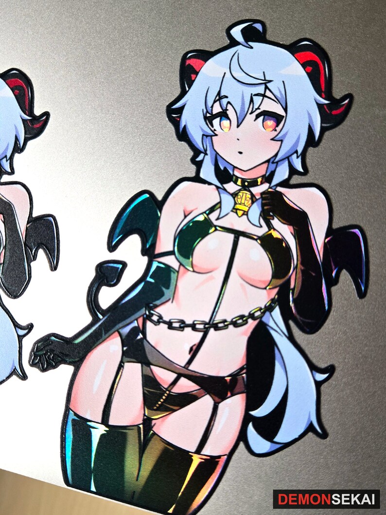 May include: A sticker featuring a cartoon character with blue hair, red horns, and a black and gold outfit. The character is wearing a chain and has a devil tail. The sticker has a holographic finish.