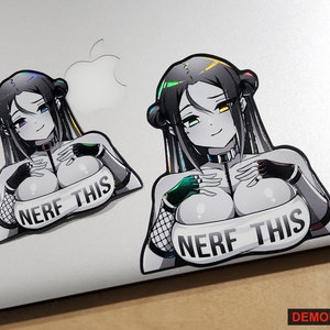 May include: A sticker featuring a black and white illustration of a woman with long black hair and a colorful iridescent design. The woman is wearing a black and white outfit and a choker. The sticker has the text "NERF THIS" on it.