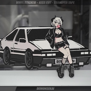 May include: A black and white illustration of a car with a female anime character sitting on the hood. The character is wearing a black leather jacket, a black skirt, and fishnet stockings. The car has the text "DEMONSEIKAI" on the back.