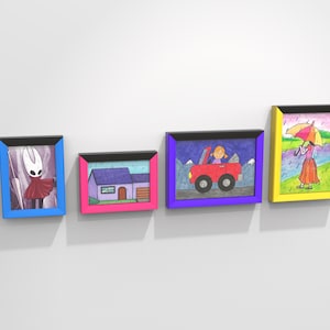 May include: Four framed drawings on a white wall. The drawings are of a house, a car, a person with an umbrella, and a character from the video game Hollow Knight. The frames are black with different colored borders: blue, pink, purple, and yellow.