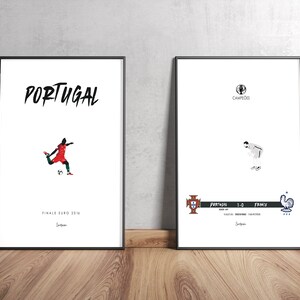 May include: Two black framed posters with white backgrounds. The left poster features a silhouette of a soccer player in a red and green uniform kicking a soccer ball. The text "PORTUGAL" is at the top of the poster and "FINALE EURO 2016" is at the bottom. The right poster features a silhouette of a soccer player in a white uniform with his head down. The text "PORTUGAL 1-0 FRANÇA" is at the bottom of the poster.